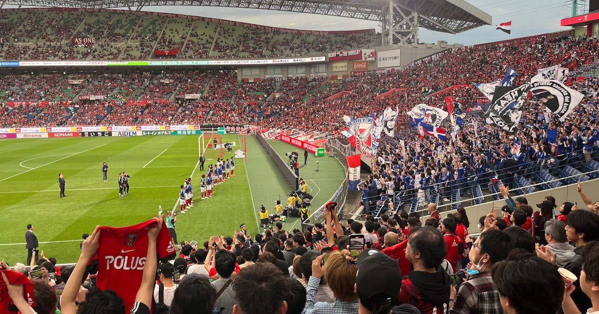 Packed Saitama Stadium with enthusiastic fans waving flags — Japan football dark horse